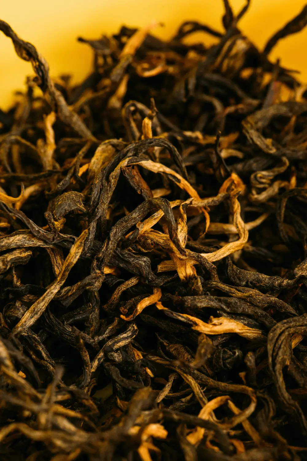 Loose oolong tea leaves and brewed amber tea